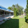 Hotel Napfeny surrounded by a green park in Balatonlelle